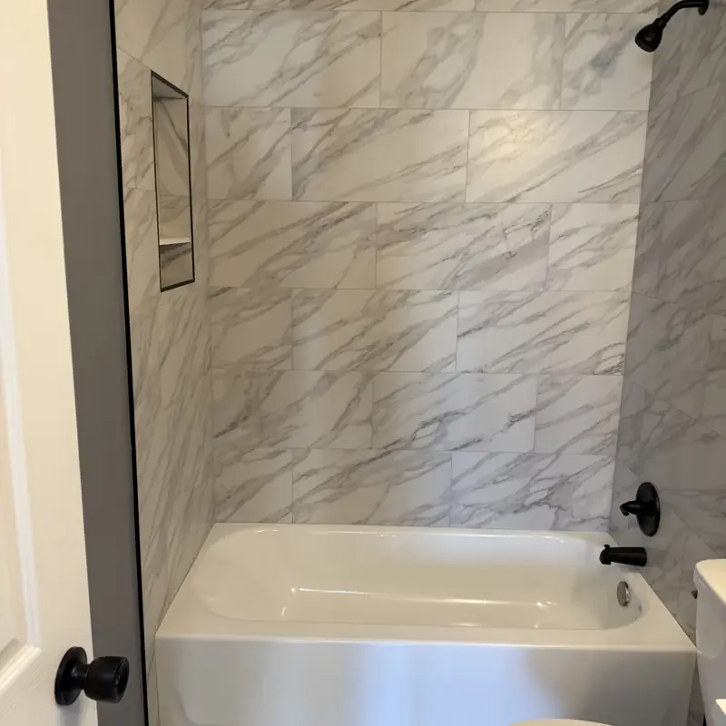 Marble tile bathroom remodel with built-in niche